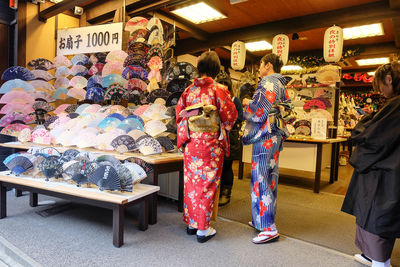 People buying hand fans at store