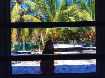 Woman sitting by window at beach