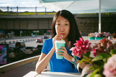 Portrait of woman having coffee while sitting at outdoor cafe