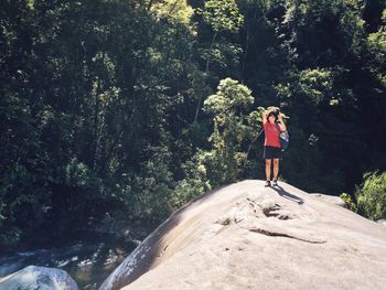 Full length of woman photographing in forest