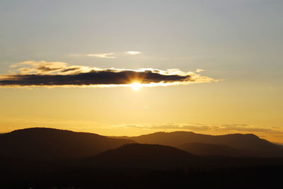 Scenic view of silhouette mountains against sky at sunset