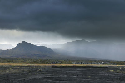 Scenic view of land and mountains against sky