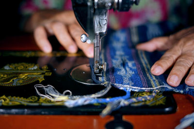 Cropped image of woman using sewing machine