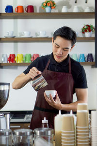 Mid adult man holding food in kitchen
