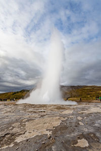 Scenic view of waterfall on landscape against sky