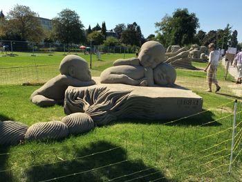 Rear view of people relaxing on field