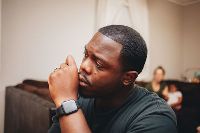 Close-up of man looking away while sitting at home