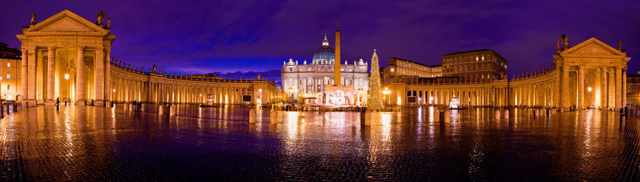 Illuminated buildings against sky at night