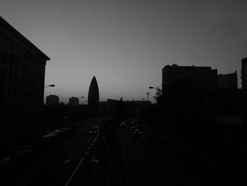 City street and buildings against clear sky during sunset