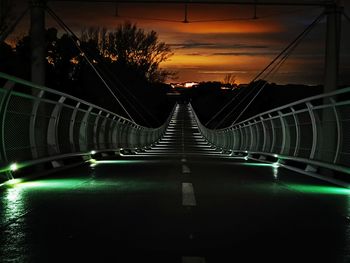Illuminated bridge against sky at sunset