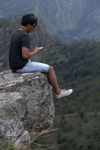 Side view of teenage girl on rock