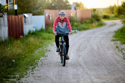 Rear view of man riding bicycle on road