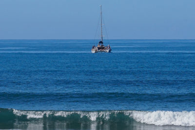 Sailboat sailing on sea against clear sky