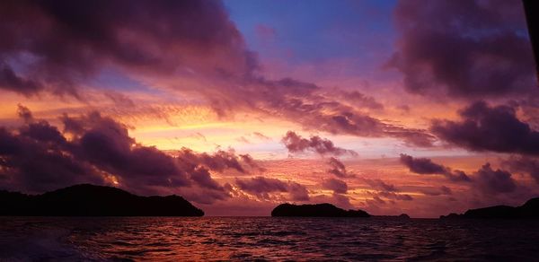 Scenic view of sea against dramatic sky during sunset