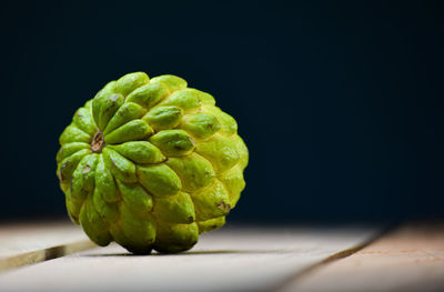 Close-up of fruit on table against black background