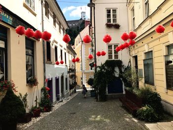 Red lanterns hanging on street amidst houses in city