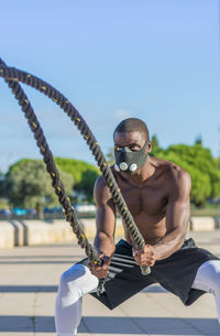 Man exercising with battle rope in park
