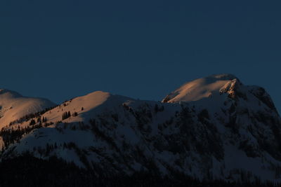 Scenic view of snowcapped mountains against clear sky