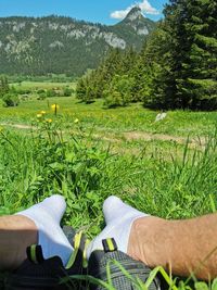 Low section of person relaxing on field