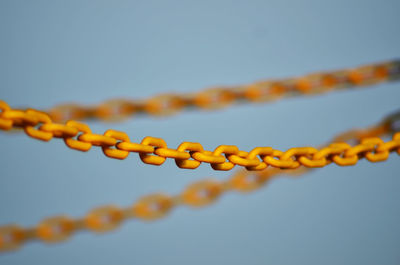 Low angle view of chain against sky during sunset