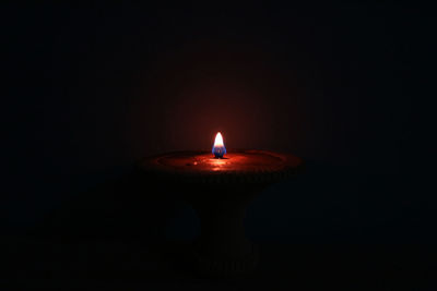 Close-up of lit candle in the dark