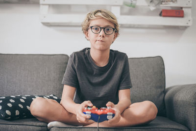 Full length of woman sitting on sofa at home