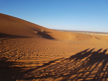 Sand dunes in desert against clear sky