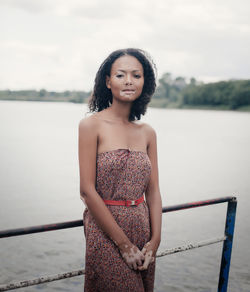 Portrait of woman suffering from vitiligo standing against lake