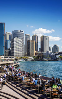 City buildings by sea against sky