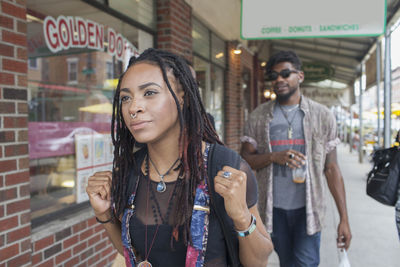 A young woman and a young man on a street.