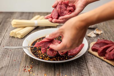 Close-up of woman preparing food on cutting board