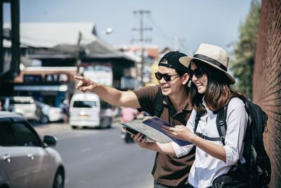 Woman using mobile phone on street in city