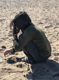 Midsection of woman on sand at beach