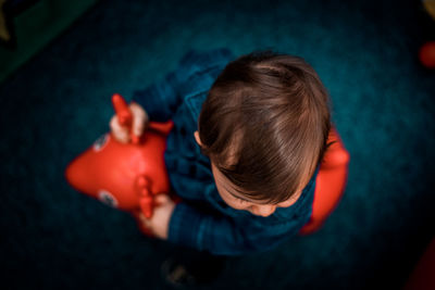 High angle view of boy playing with toy at home