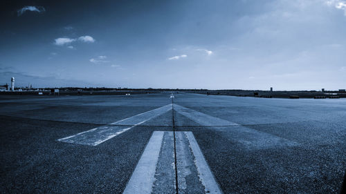 Surface level of airport runway against sky