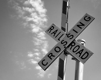 Low angle view of road sign against sky