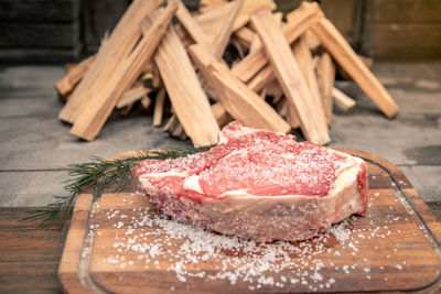 Closeup italian steak ready to be cooked on a barbecue. appetizing piece of meat, pyre of firewood 