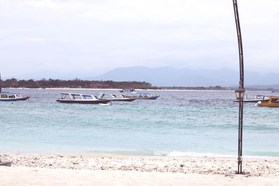 Sailboats moored on sea against sky