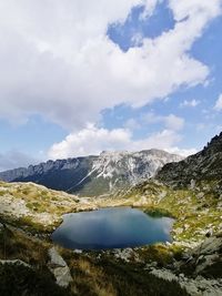 Scenic view of lake by mountains against sky