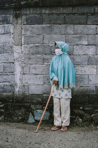 Rear view of woman standing on footpath