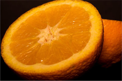 Close-up of orange slice against black background