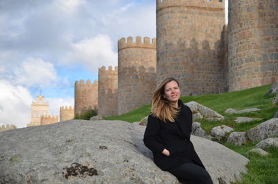 Portrait of smiling woman against historic building