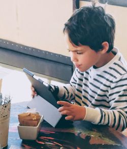 Boy looking away while sitting on table