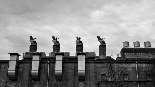 Low angle view of buildings against cloudy sky