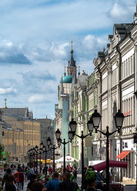 People on town square against cloudy sky