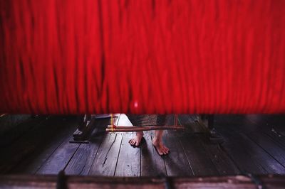 Low section of person standing by red handloom