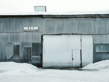 Snow covered building against sky during winter