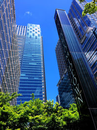 Low angle view of modern buildings against blue sky