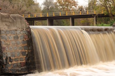 Waterfall against footbridge in forest