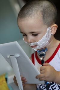 Close-up of boy shaving at home